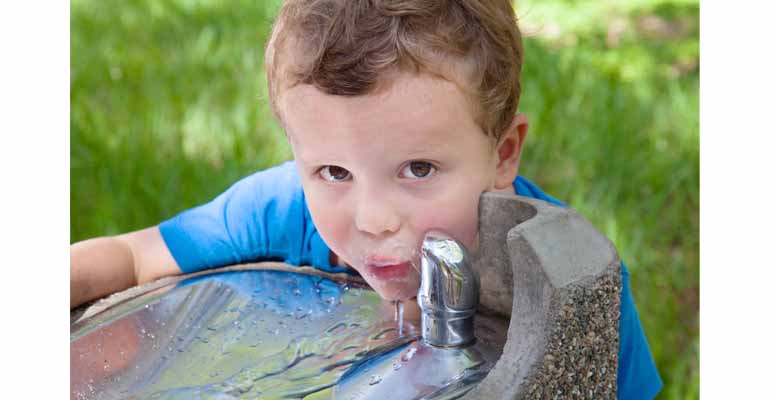 Niño bebiendo agua de calidad de la fuente